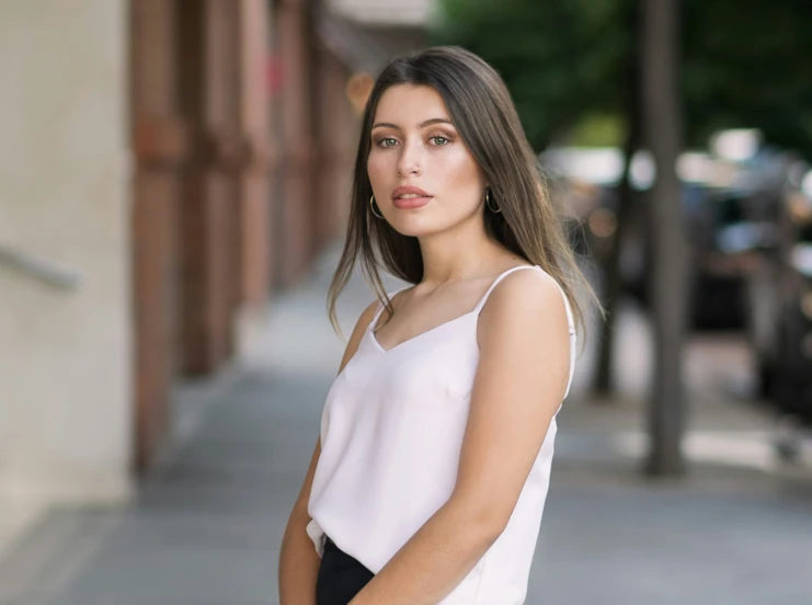 a woman wearing a black pants and a white shirt