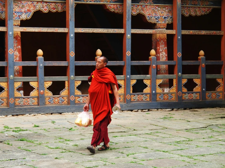 a man in a red robe carrying a sack in his hand