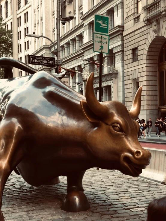 a statue of a bull is standing on brick pavement