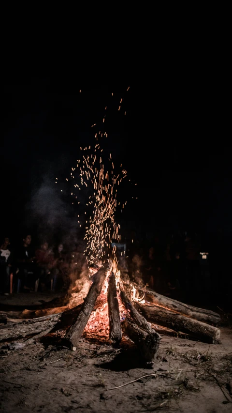 a campfire with large, colorful fireflies lit up at night