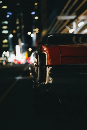 a red car sits on the road at night