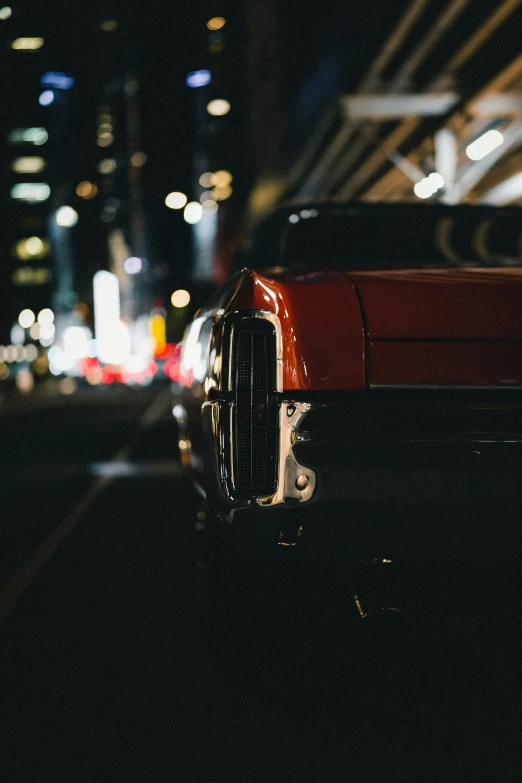 a red car sits on the road at night