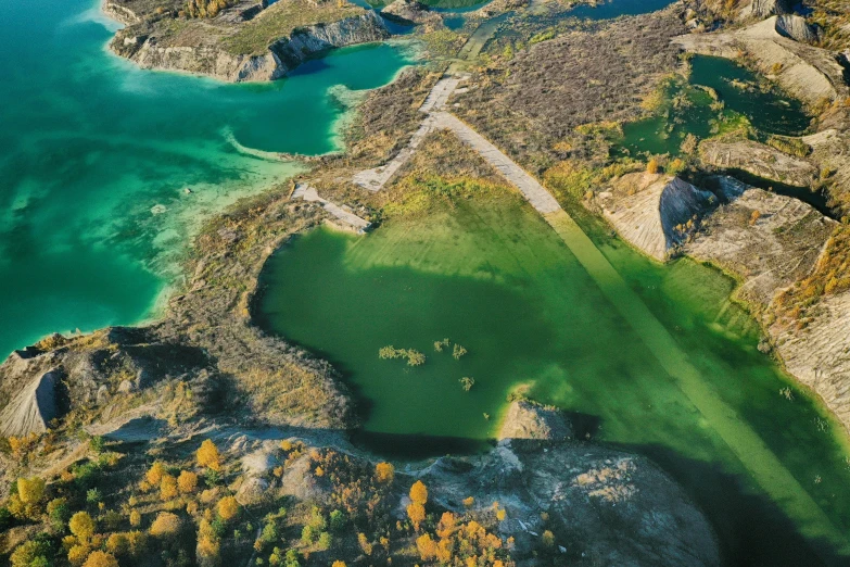 an aerial view shows a large pond, land and water