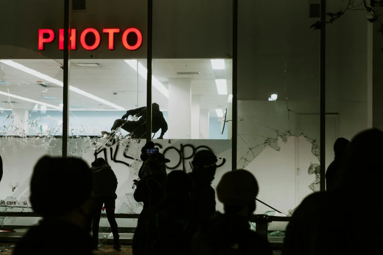 people stand around a building with a po displayed on it