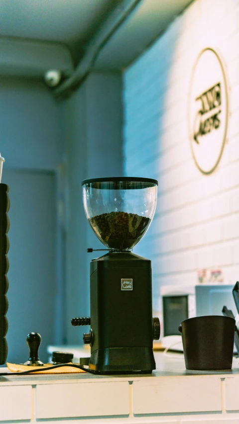 a coffee maker sitting on top of a counter next to cups