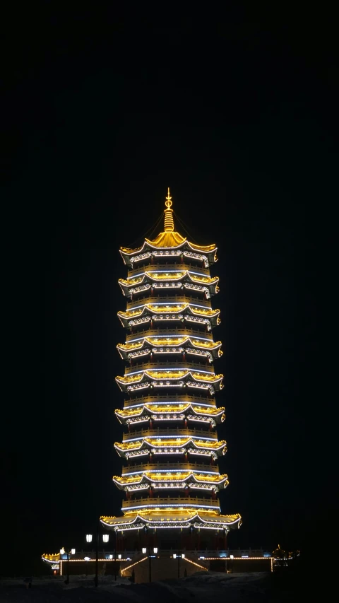 the tall tower is illuminated at night time