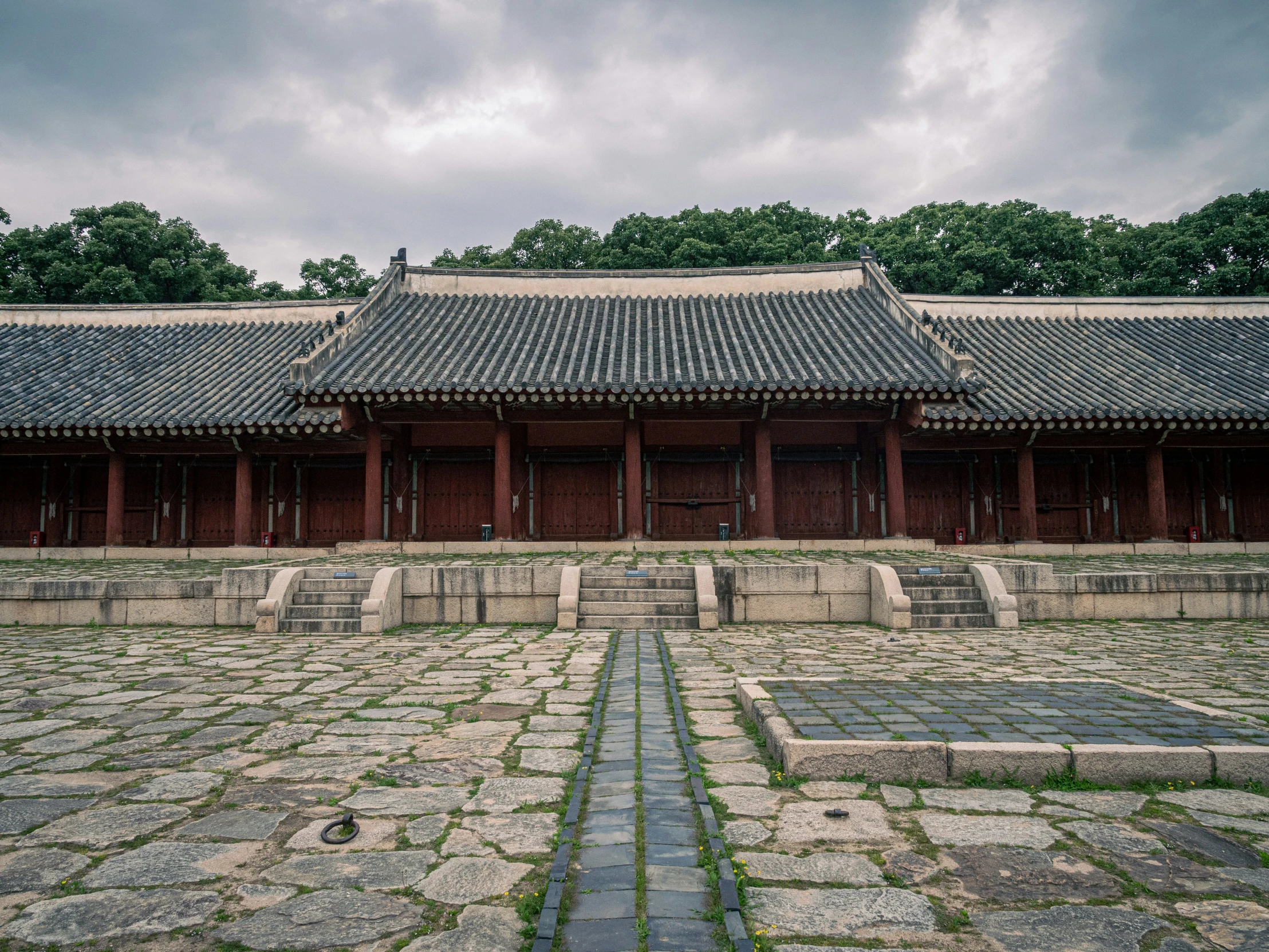 a building with a long stone walkway on the ground