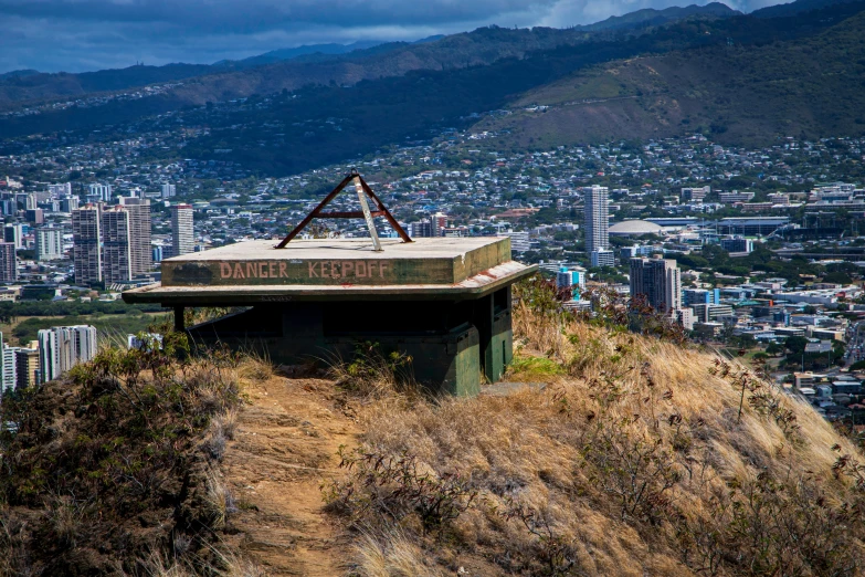 a rundown building sits on top of a hill in front of the city