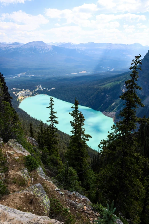 a turquoise lake sits in the center of mountains