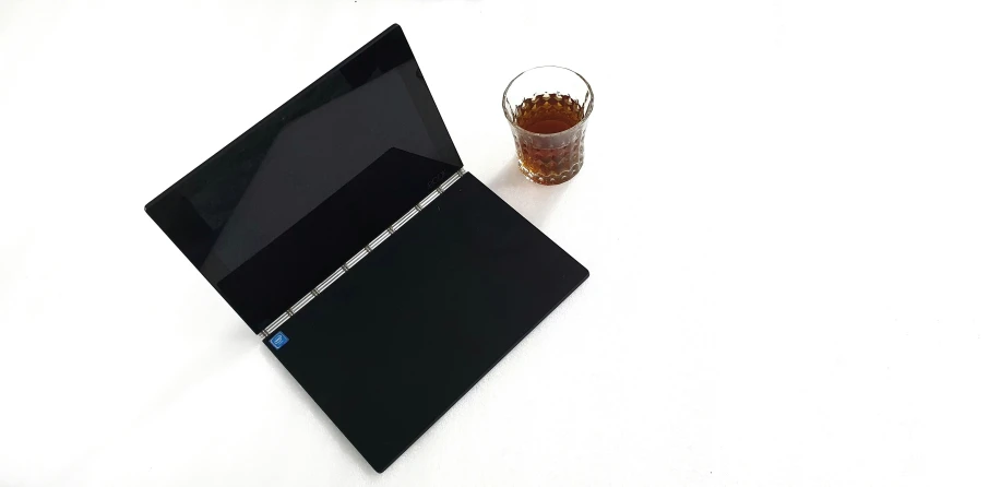 a black ipad with a drink on it