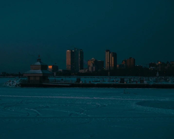 a train traveling on tracks by a river near a city