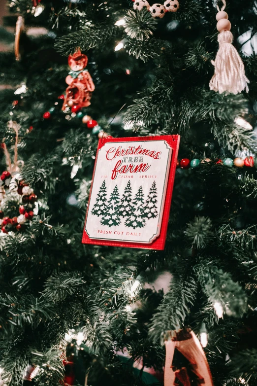 a handmade christmas sign hanging from the tree