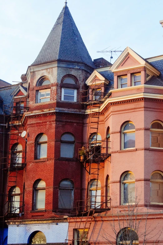 a brick building with multiple floors and a spire