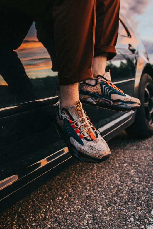 a pair of people stepping on to the back end of a car