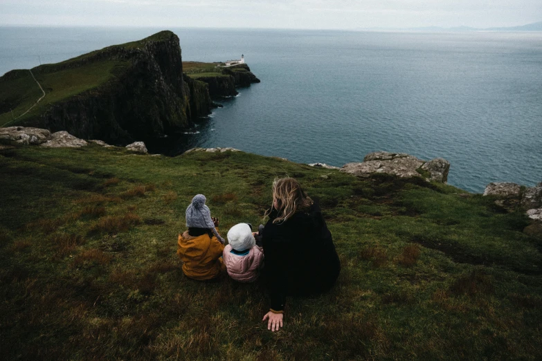 two people looking out at the ocean from top of a cliff