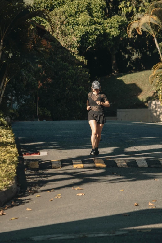 a woman jogging in the street with trees behind her