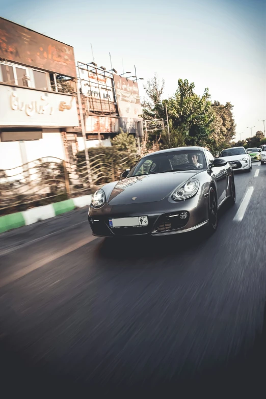 two porsche cars driving along the highway in front of some buildings