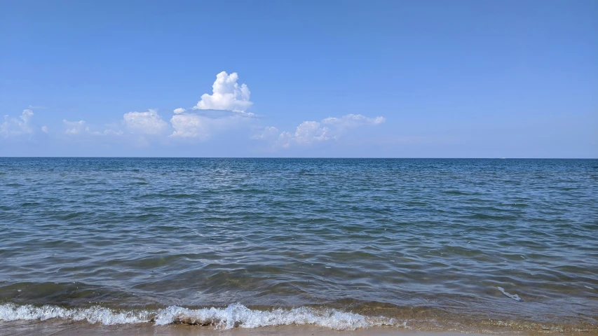 the ocean with waves rolling along on sand