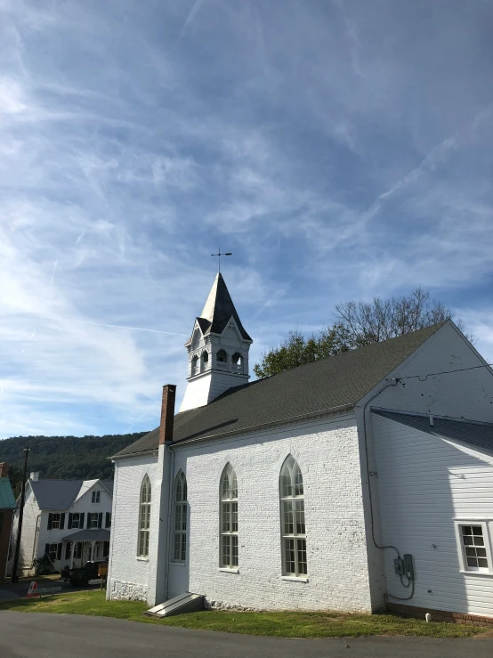 an old white church is surrounded by small houses