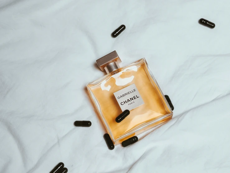 the bottle of perfume on top of a white sheet