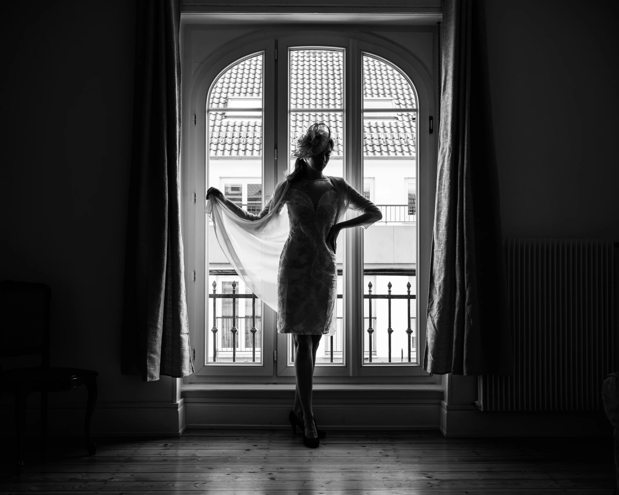 a young woman in a short dress is standing by an open window