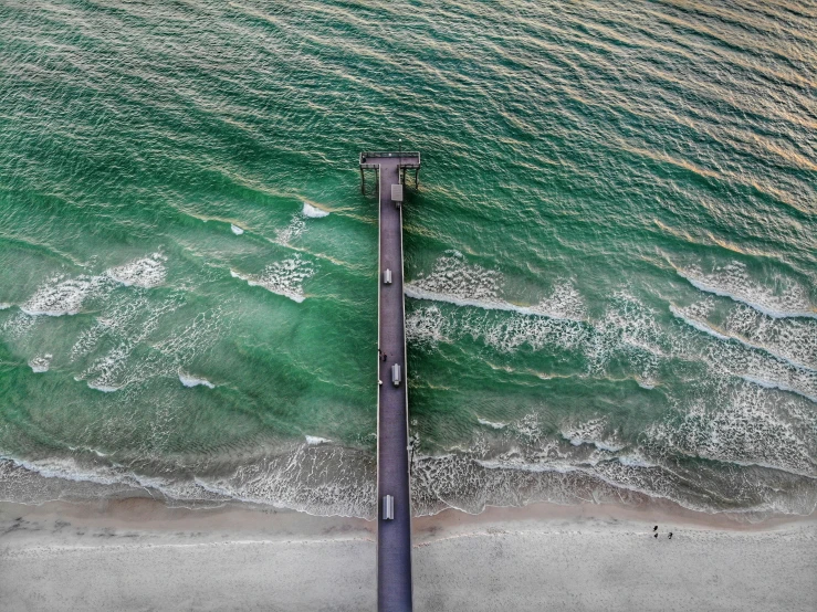 aerial view of pier and the ocean in blue and green