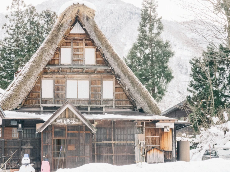 an older wood structure with a thatched roof on it