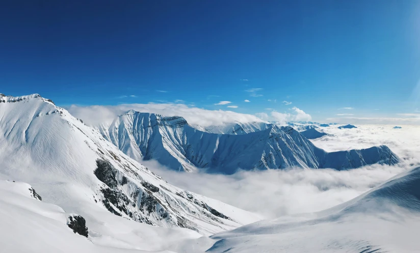 the view from the top of a mountain looking down on the snowy mountains