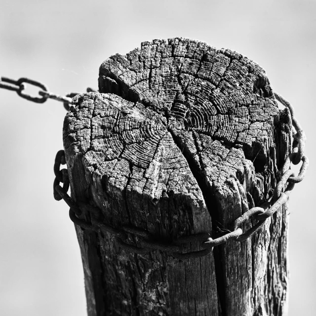 an old wooden post with chains attached to it