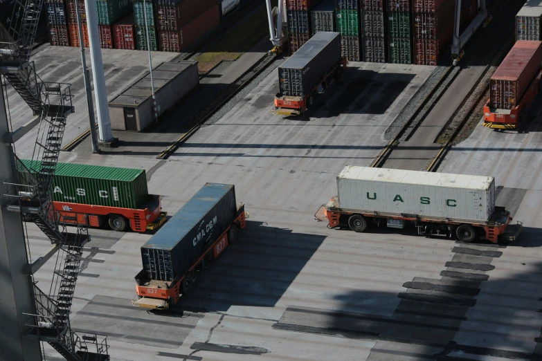 trucks are parked near cargo containers in the yard