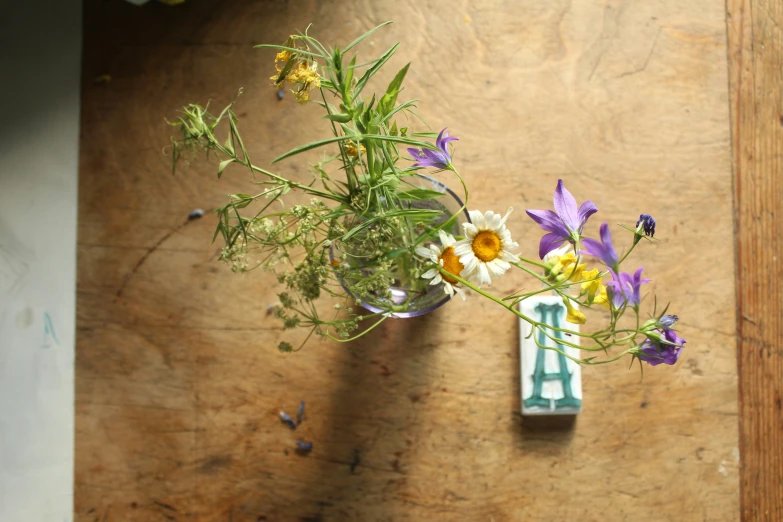 a wooden table with flowers and some kind of blue vase