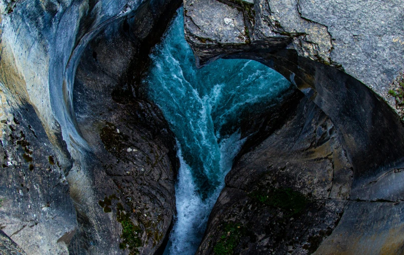 the water is flowing between some rocks