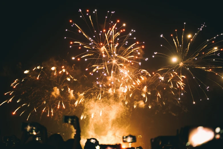 a night scene with a firework display and people watching