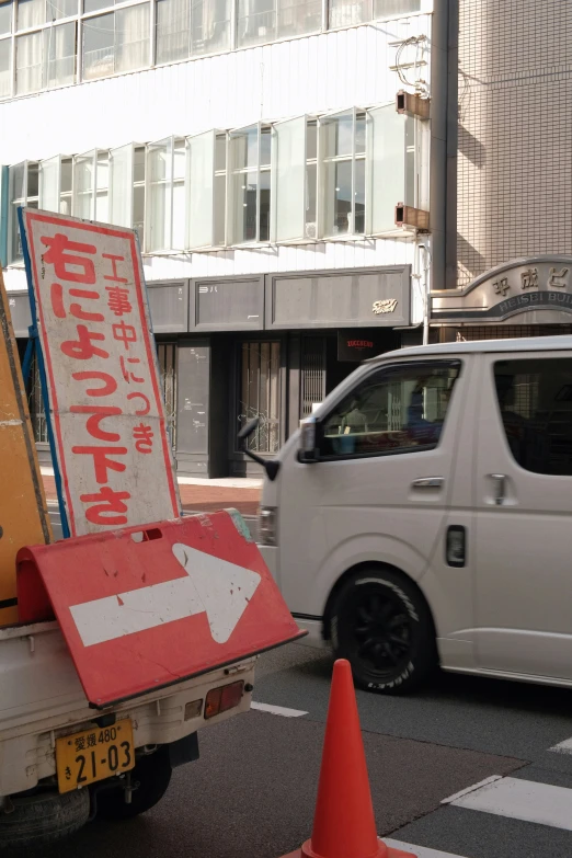 a white van is on the street with an upside down sign