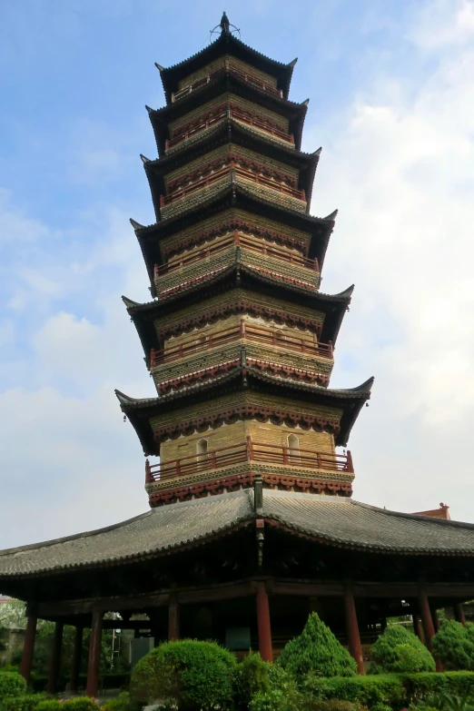 tall pagoda sits atop a building in a garden