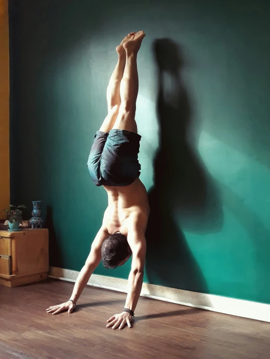 a person standing up in a back handstand while practicing yoga