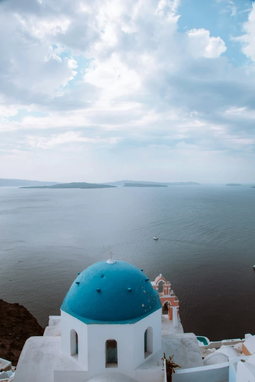 a white and blue building on the edge of a cliff