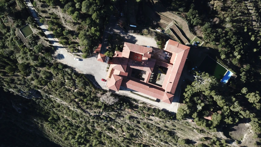 an aerial s of a red house in a forest