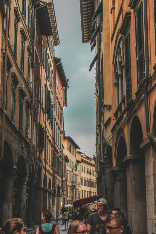 people walk down an alley way between some buildings