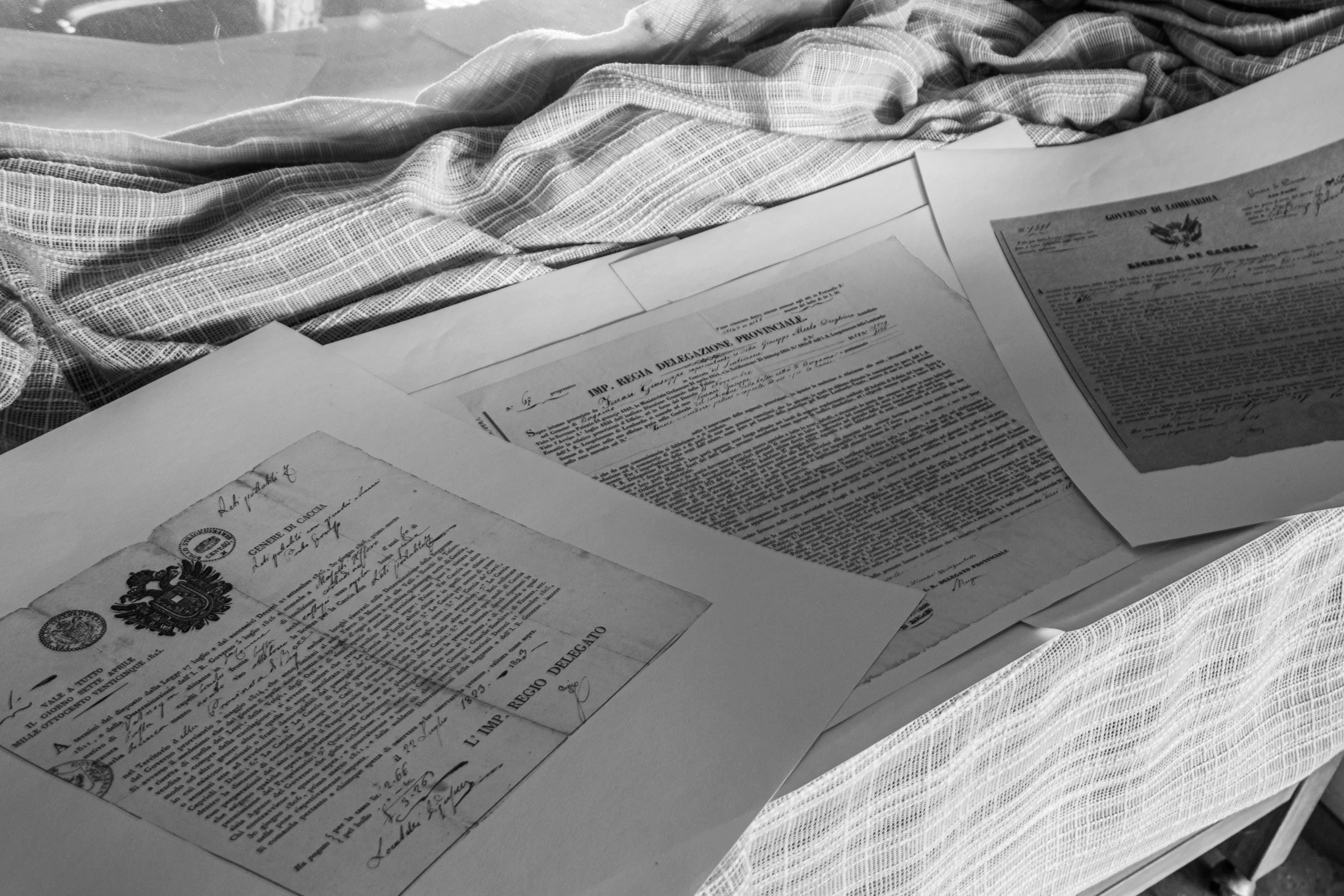 a pile of open papers on top of a bed