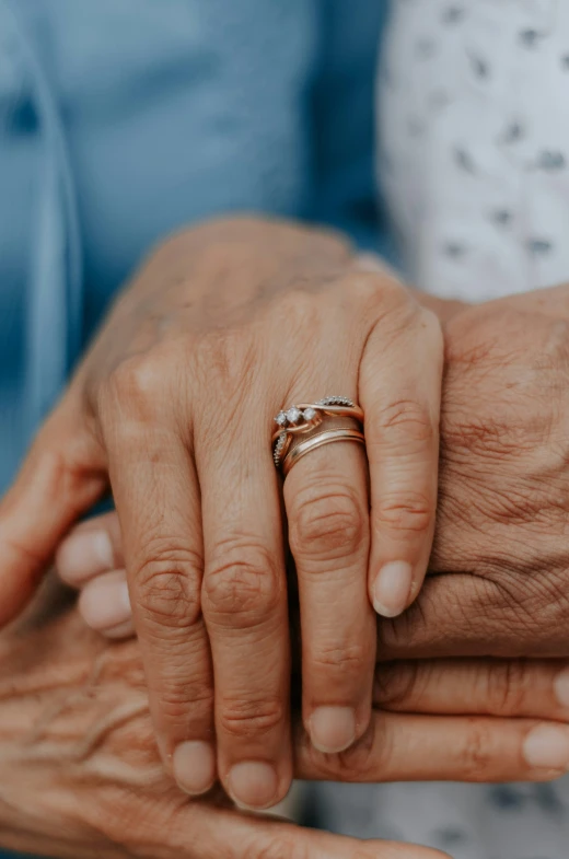 close up of two adults holding hands one of which is holding the other