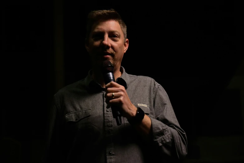 a man in a on up holds a microphone
