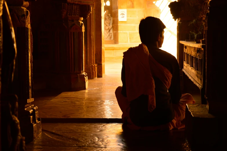 a woman is sitting in a dimly lit room