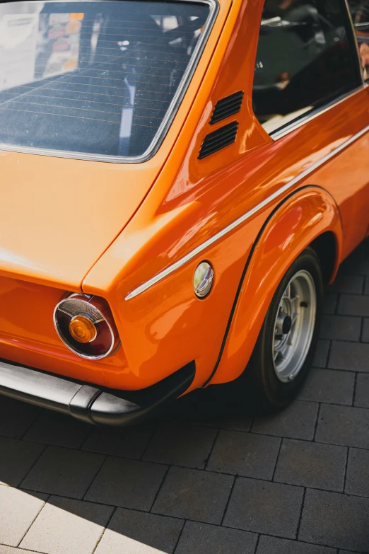 an orange car sitting outside of a building