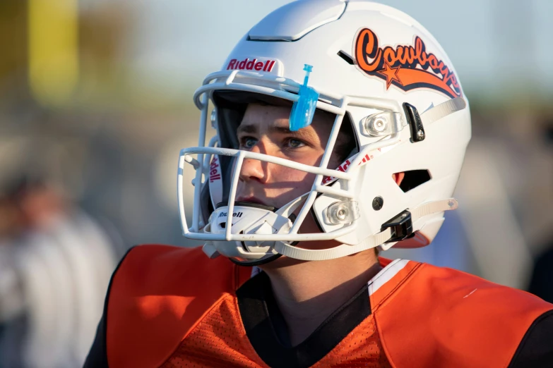 young football player in a helmet looks off into the distance