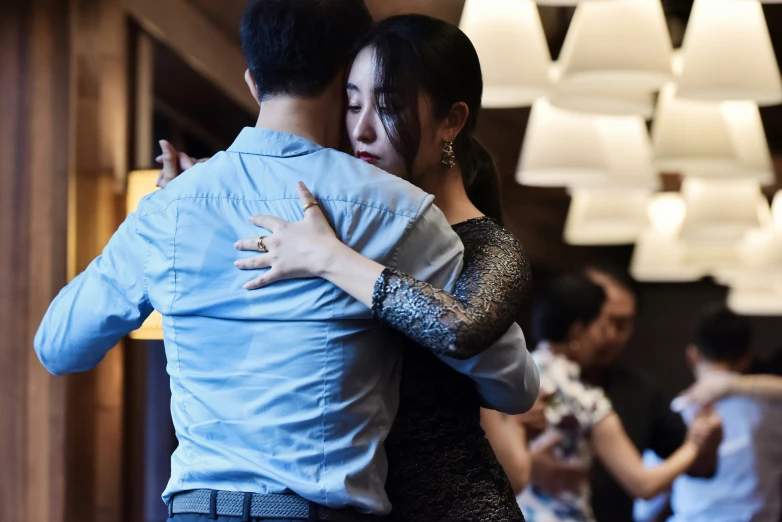 two people standing close together and hugging at the same time