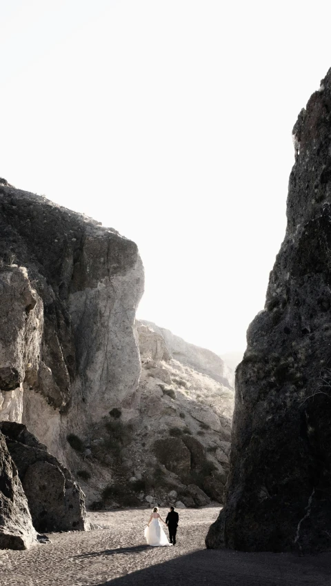 a couple walks through an open rock field