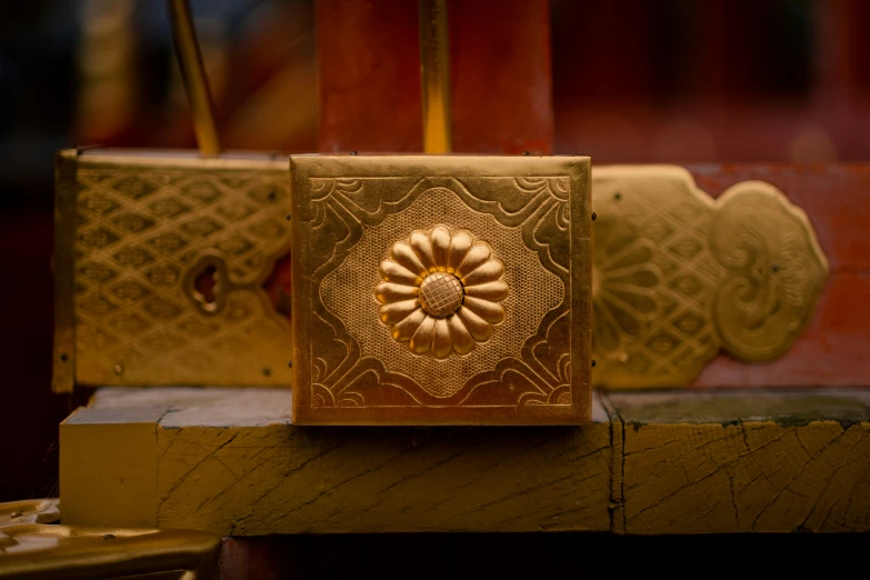 a box sitting on a wooden piece with designs on it