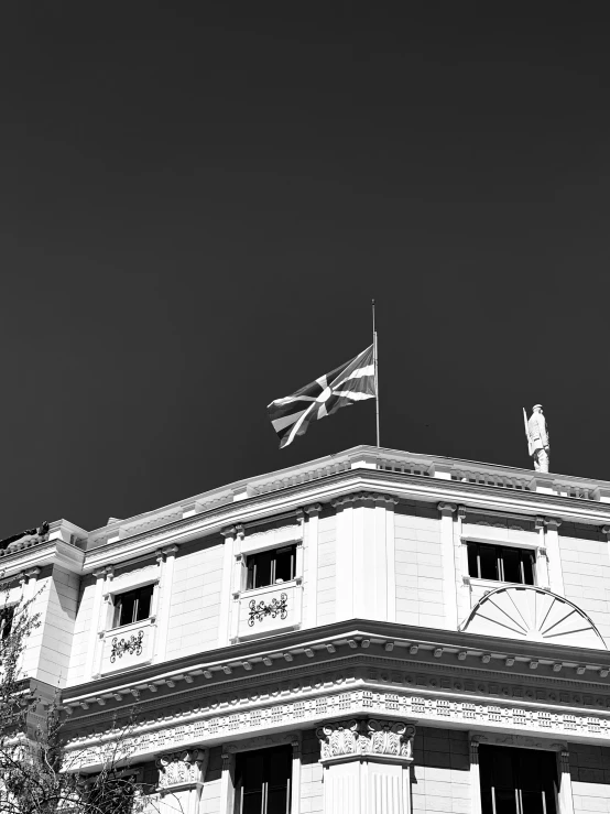 the roof of an old building with a clock and a flag