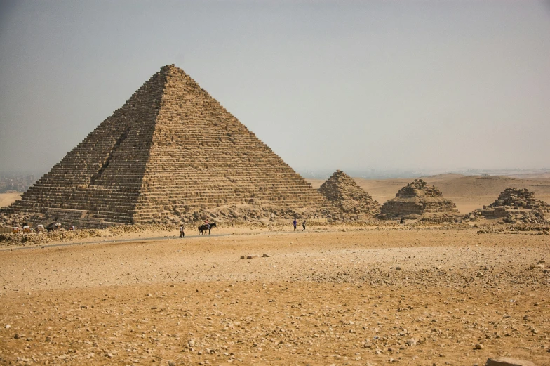 two men on horses walking next to the pyramids in egypt